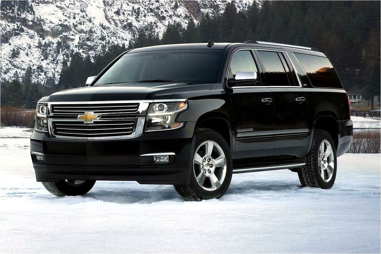 Black SUV parked on snow with a mountainous landscape in the background.